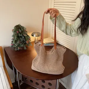 Handmade hollow crochet straw beach bag with tan leather shoulder straps for summer