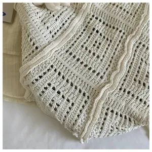 Close-up detail of beige crochet beach bag showing intricate hollow-out knit pattern