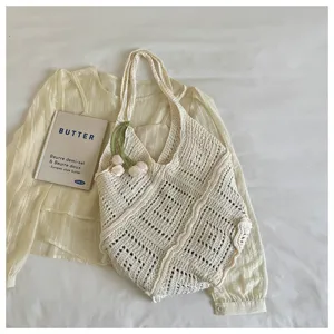 Close-up of a bohemian cream knitted hollow-out tote bag with unique wavy edges