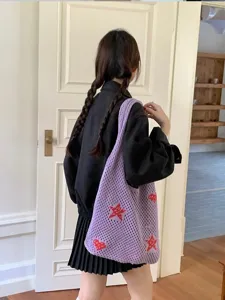 Lifestyle view of purple knitted tote bag with red stars and hearts on model