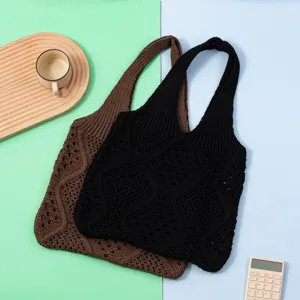 Primer plano de elegantes bolsos de punto calados en colores marrón y negro para verano