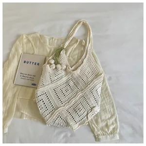 Detail shot of cream-colored Bohemian crochet hollow-out knit tote bag for beach trips