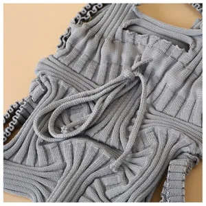 Macro view of grey knitted pleated mini crossbody bag with rope-like strap details