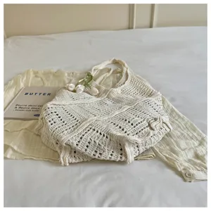 Detailed view of bohemian white crocheted tote bag with intricate hollow-out weave