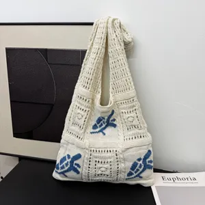 Casual gebreide draagtas met blauw bloemenpatroon in een chique lifestyle-omgeving