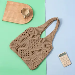 Primer plano de un bolso tote de punto marrón calado con patrón de diamantes para mujer