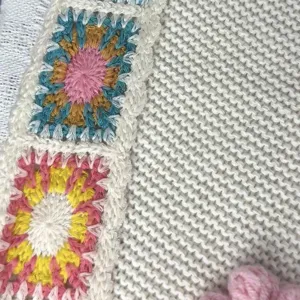 Close-up detail of the handmade crochet granny square and knit texture on the casual shoulder bag.