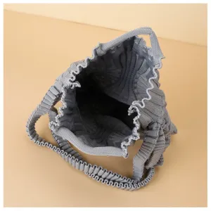Top-down view of a grey knitted pleated mini crossbody bag showing its woven interior