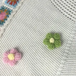 Detailed view of the handmade floral knit shoulder bag with cute crochet flower accents.