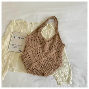 Close-up of bohemian brown hollow-out crochet tote bag on a stylish cream blouse