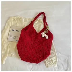 Close-up shot of red handmade crochet knit tote bag featuring intricate hollow patterns
