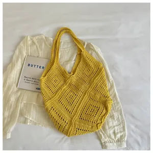Yellow bohemian knitted tote bag with hollow diamond pattern, lifestyle detail view