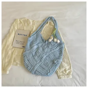 Detailed macro view of a light blue hollow-out knit bohemian beach tote bag texture