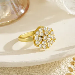 Close-up detail of a gold-plated hexagonal ring with a sparkling zircon cluster inlay