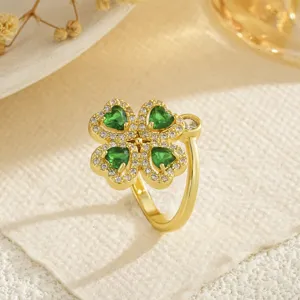 Close-up detail of golden ring featuring rotatable clover with heart-shaped green zircons