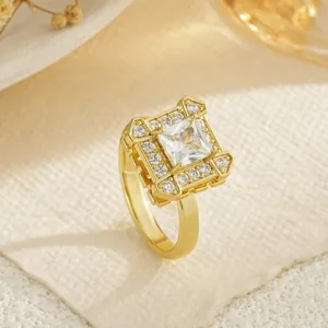 Macro detail of a gold rotatable copper ring featuring a sparkling square zircon center stone.