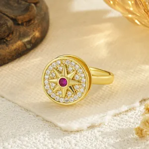 Close-up of a gold-plated rotating ring with a star motif and zircon stones