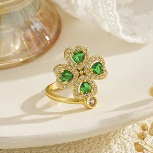 Detailed view of a rotating four-leaf clover ring with green heart-shaped zircons