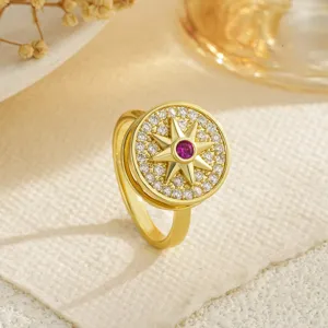 Macro view of gold-plated spinning ring with star motif and red gemstone center