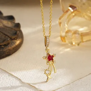 Close-up of vintage gold shooting star necklace with red and white zircon accents