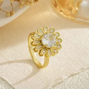 Gros plan d'une bague fleur plaquée or luxueuse avec des zircons étincelants et des pétales.