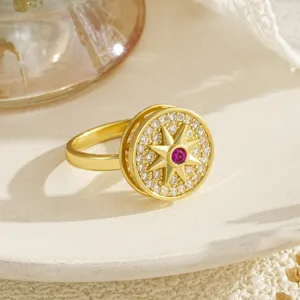 Close-up of a rotating gold stress-relief ring with star pattern and zircons
