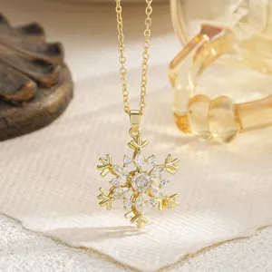 Elegant gold snowflake rotating pendant necklace with shimmering cubic zirconia stones