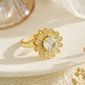 Vue détaillée d'une bague fleur rotative dorée avec pétales en zircons sertis.