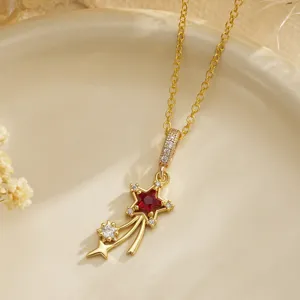 Macro view of gold shooting star necklace with red ruby-like gemstone and clear zircons
