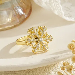 Detailed view of a rotating golden snowflake ring decorated with shimmering zircon stones