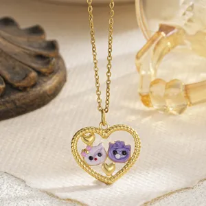 Close-up detail of the gold heart pendant with purple and pink enamel kitten faces