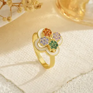 Close-up of a rotatable gold-plated ring featuring a colorful zircon four-leaf clover
