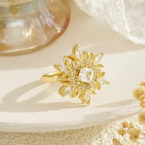 Vue détaillée d'une bague fleur plaquée or avec pétales rotatifs et zircons brillants.