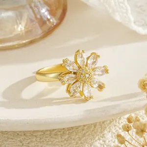 Détail macro d'une bague fleur en or rotative élégante avec pétales en zircon incrustés.