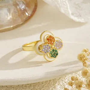 Close-up of rotating gold clover ring with colorful micro-set zircons and enamel