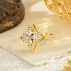 Close-up detail of a golden rotating clover ring set with sparkling marquise zircons