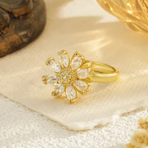 Détail macro d'une bague fleur plaquée or avec des pétales en zircone scintillants.