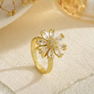 Gros plan détaillé d'une bague fleur rotative en or avec des zircons en taille marquise.