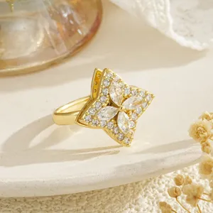 Macro view of a rotatable gold ring featuring a sparkling zircon four-leaf clover design