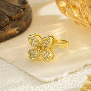 Close-up detail of a rotatable gold-plated four-leaf clover ring with sparkling cubic zirconia
