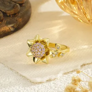 Détail macro exquis d'une bague tournesol dorée ornée d'un pavage en zircone rose