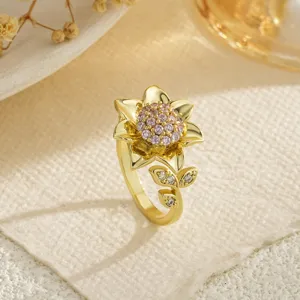 Gros plan détaillé d'une bague tournesol dorée avec zircons roses et détails de feuilles
