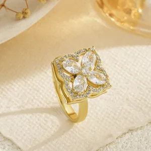 Macro view of a gold-plated rotating four-leaf clover ring with marquise cubic zirconia.