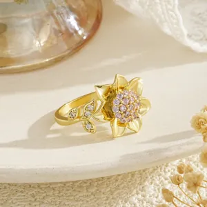 Détail macro d'une élégante bague fleur en or avec centre en zircon rose et accents de feuilles