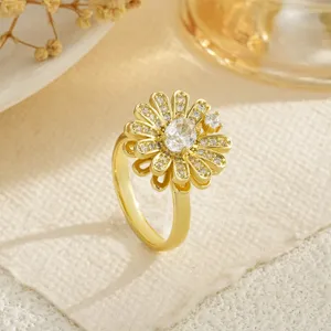 Gros plan d'une bague fleur dorée avec des pétales sertis de zircons étincelants