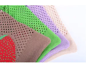 Detail view of colorful crochet mesh tote bags with a strawberry pattern design