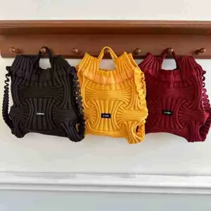 Detailed view of three colorful knitted woven backpacks hanging on a rustic wooden rack.