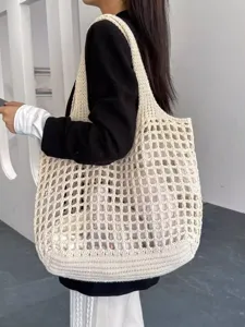 Détail du sac cabas au crochet crème avec motif tricoté ajouré moderne sur le mannequin