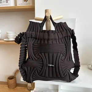 Close-up detail of dark brown knitted backpack with unique textured woven pattern