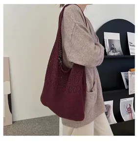 Detail view of the burgundy hollow-out knit shoulder bag worn by a model in a studio